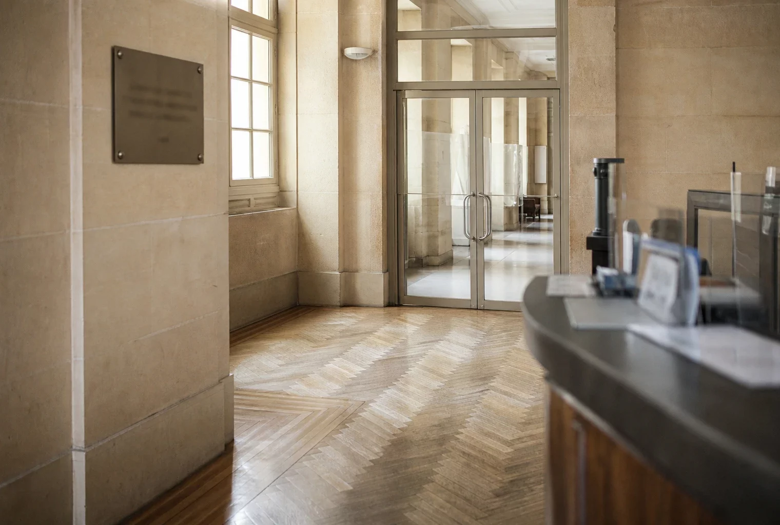Couloir vide du ministère de la Justice, lumière naturelle claire et ambiance institutionnelle calme.