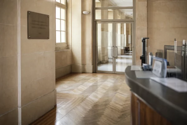 Couloir vide du ministère de la Justice, lumière naturelle claire et ambiance institutionnelle calme.