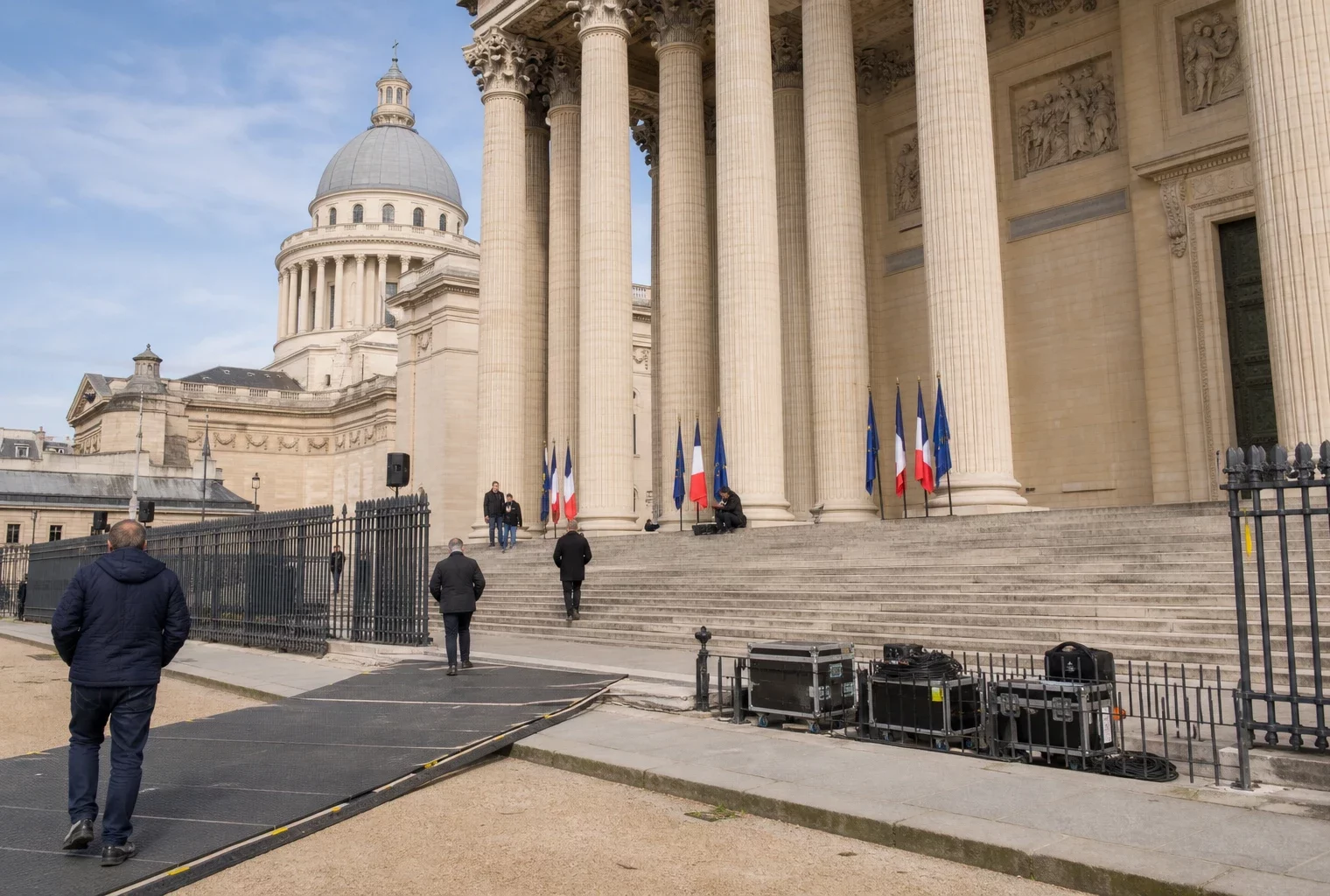 Le Panthéon à Paris pendant la préparation d’une cérémonie, avec des silhouettes anonymes et un accès sécurisé calme.