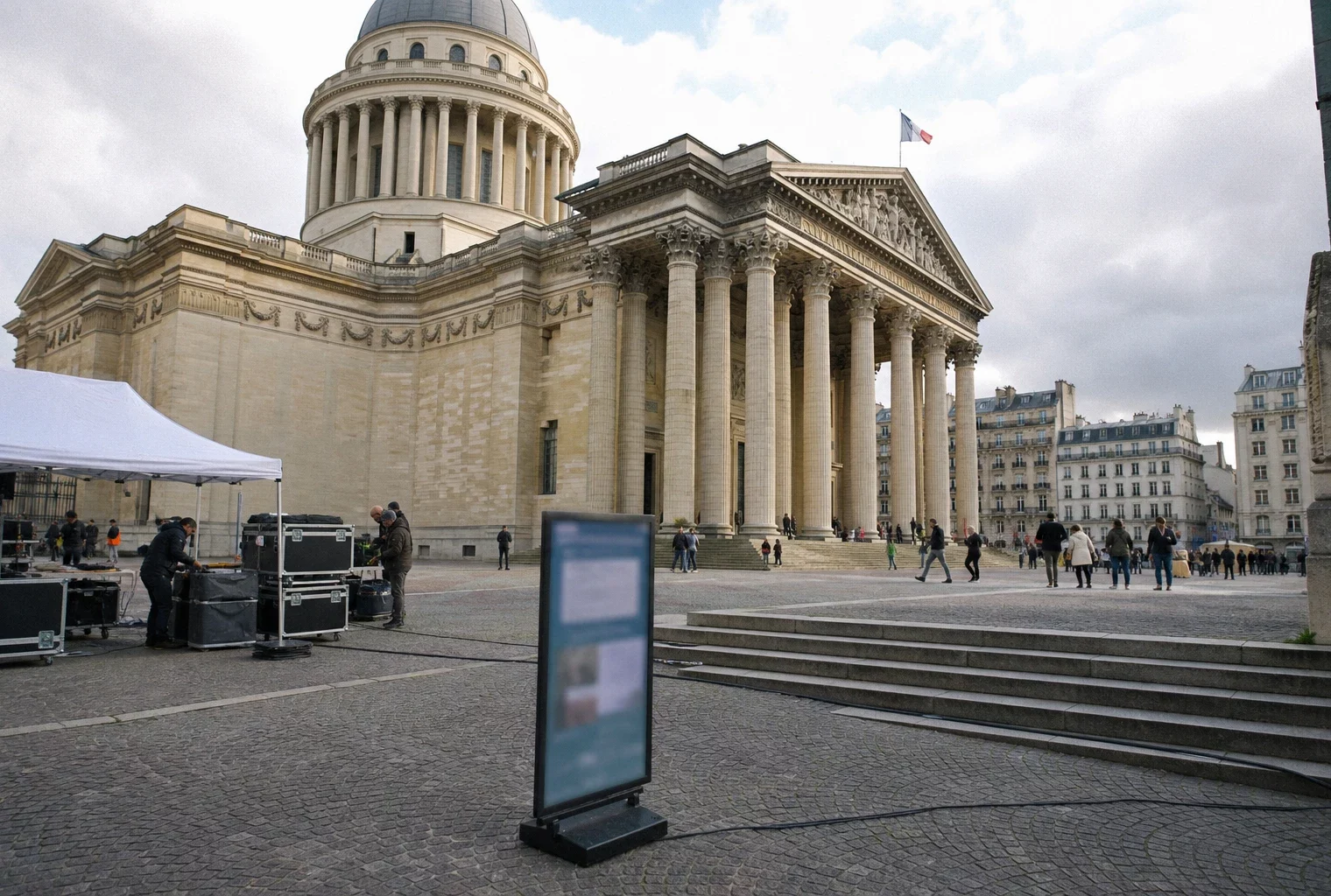 Le Panthéon à Paris lors des préparatifs d’une cérémonie, avec des techniciens et visiteurs anonymes sur le parvis.