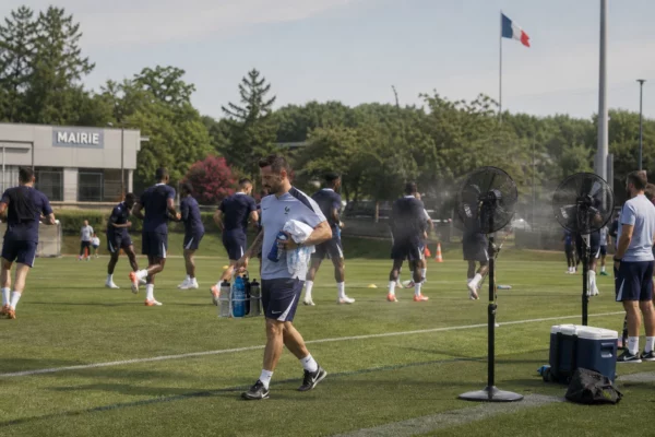 Préparation des Bleus sur un terrain d’entraînement américain, avec eau, serviettes et chaleur estivale en arrière-plan