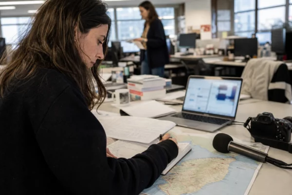 Journaliste dans une rédaction française préparant un sujet sur la réforme constitutionnelle corse.
