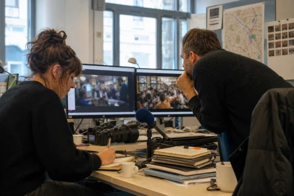 Dans une rédaction parisienne, des journalistes préparent un sujet sur un pub d’Édimbourg soutenant la Côte d’Ivoire.