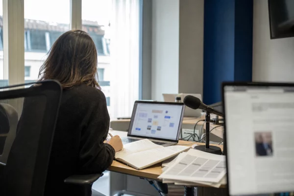 Journaliste dans une rédaction lumineuse préparant un sujet sur les institutions européennes et les nominations