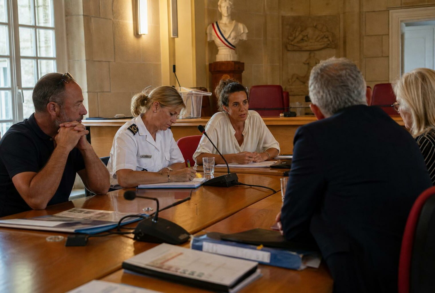 Réunion dans une mairie française après les violences liées à la victoire du PSG, avec élus et riverains autour d’une table.