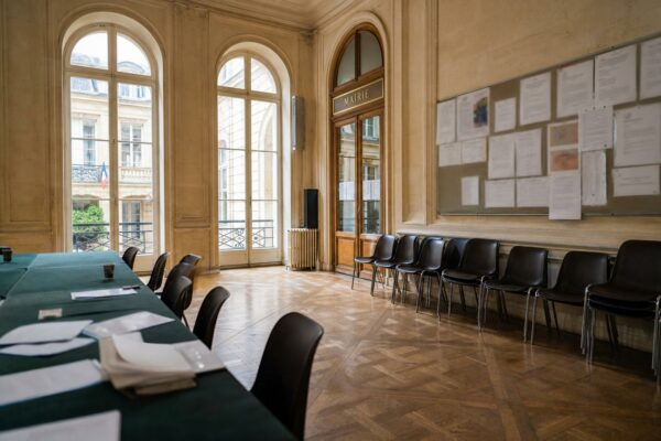 Salle vide d’un siège politique français avant un congrès, avec lumière naturelle et atmosphère institutionnelle calme.