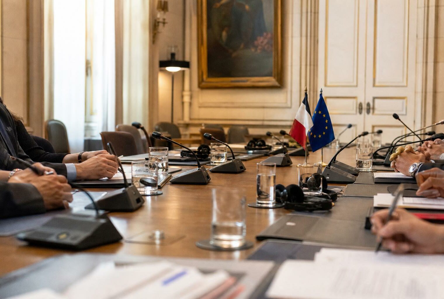 Réunion diplomatique à Paris avec dossiers fermés, micros et petits drapeaux discrets sur une table de négociation.
