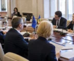 Réunion institutionnelle UE-Moldavie à Chișinău avec dossiers, micros de table et drapeaux discrets.