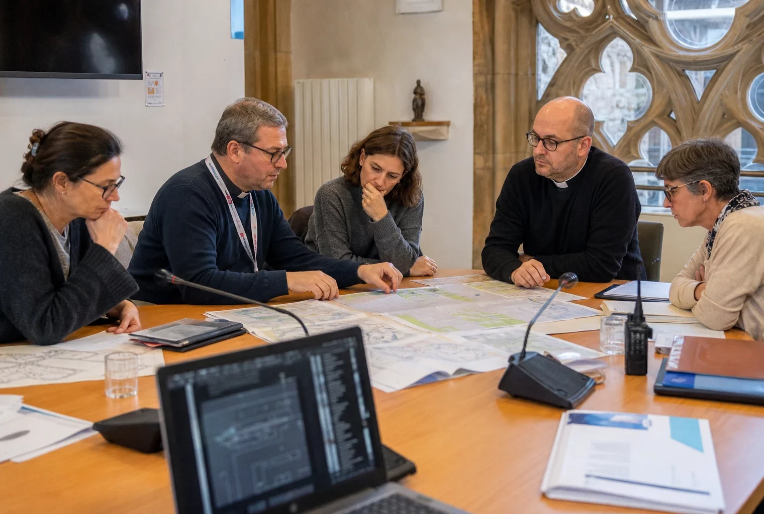 Réunion de préparation à Metz avec des organisateurs anonymes autour de plans et micros, près du quartier cathédral.