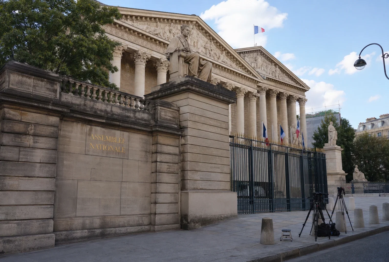 Façade de l’Assemblée nationale à Paris avec quelques trépieds de presse, sous une lumière naturelle claire.