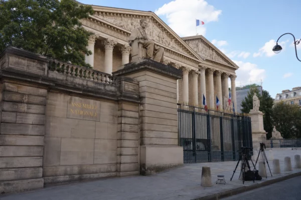 Façade de l’Assemblée nationale à Paris avec quelques trépieds de presse, sous une lumière naturelle claire.