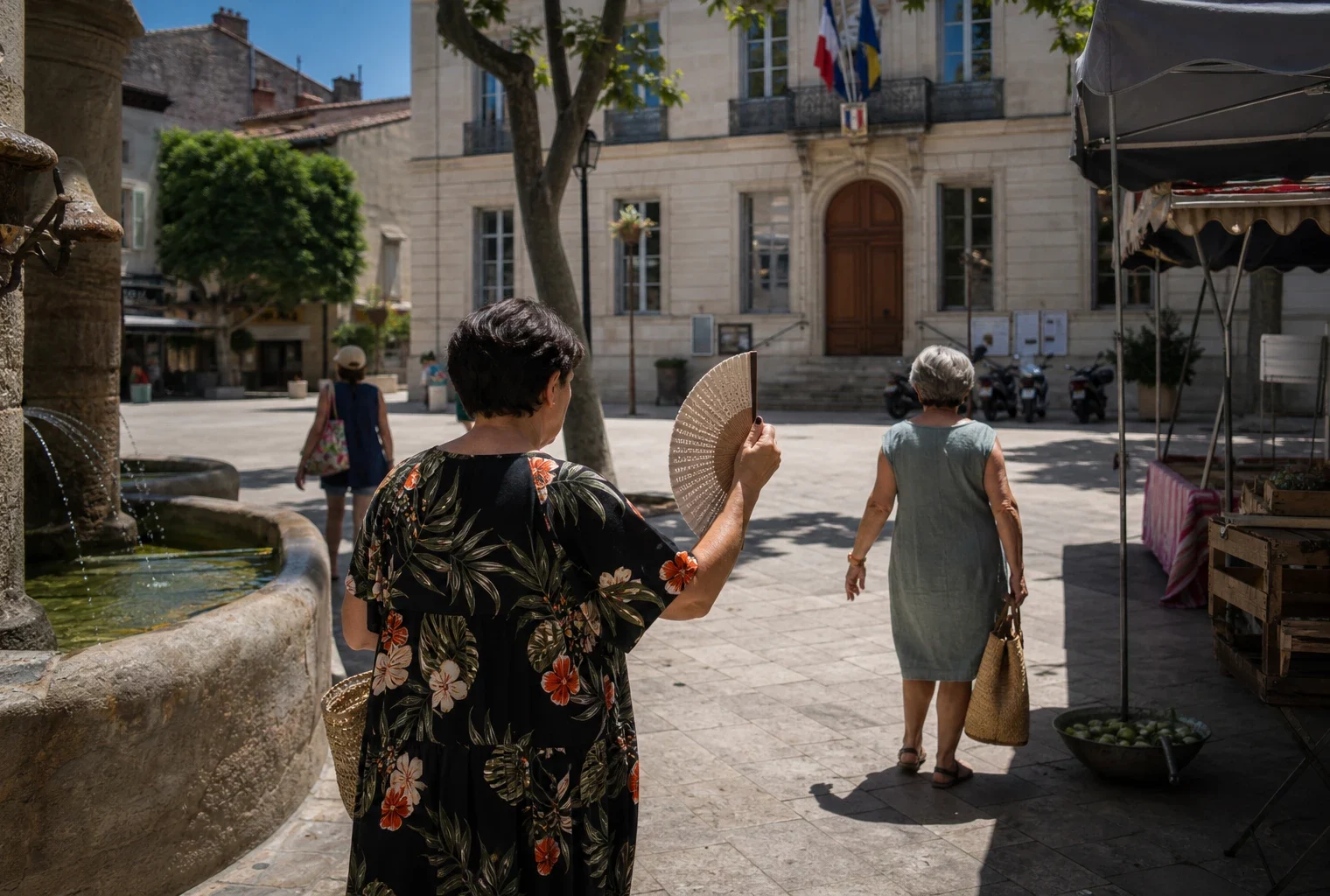 Place de ville moyenne en France avec habitants anonymes à l’ombre, un cadre de reportage sur la chaleur et l’adaptation locale.