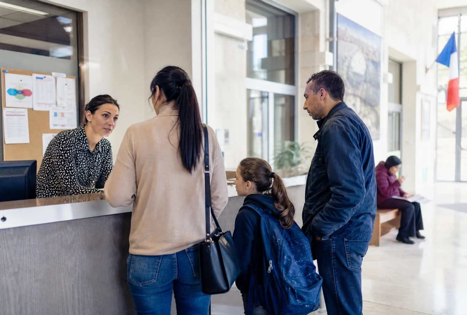 Des habitants anonymes discutent dans le hall lumineux d’une mairie française avec un enfant en cartable.