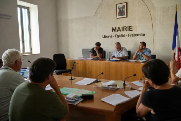 Salle municipale en Andalousie avec chaises vides, micros et dossiers après l’incendie de Los Gallardos.