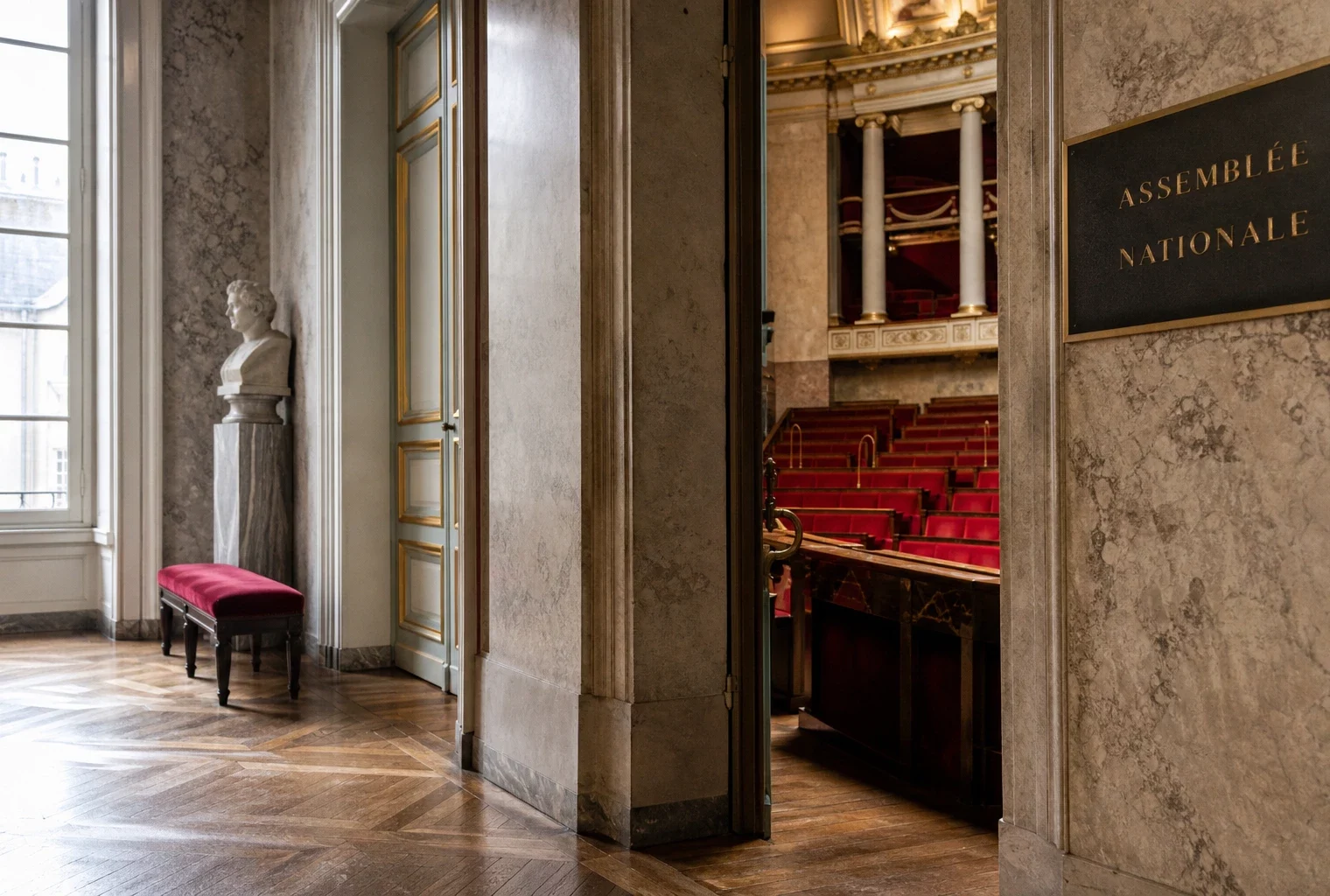 Couloir vide de l’Assemblée nationale avec lumière naturelle et sièges rouges visibles en arrière-plan