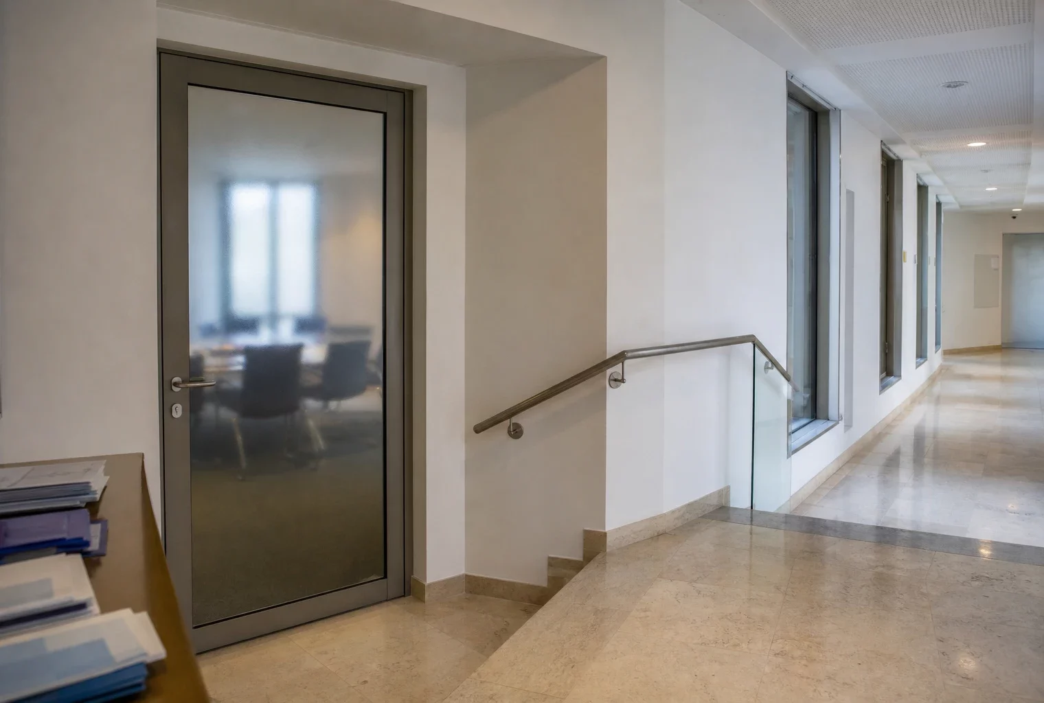 Couloir clair d’une institution publique française, porte sobre et lumière naturelle, vue d’ensemble en photo de presse.