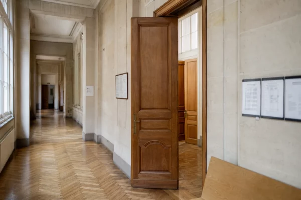 Couloir lumineux d’un bâtiment de justice français, vide et photographié en léger angle oblique.