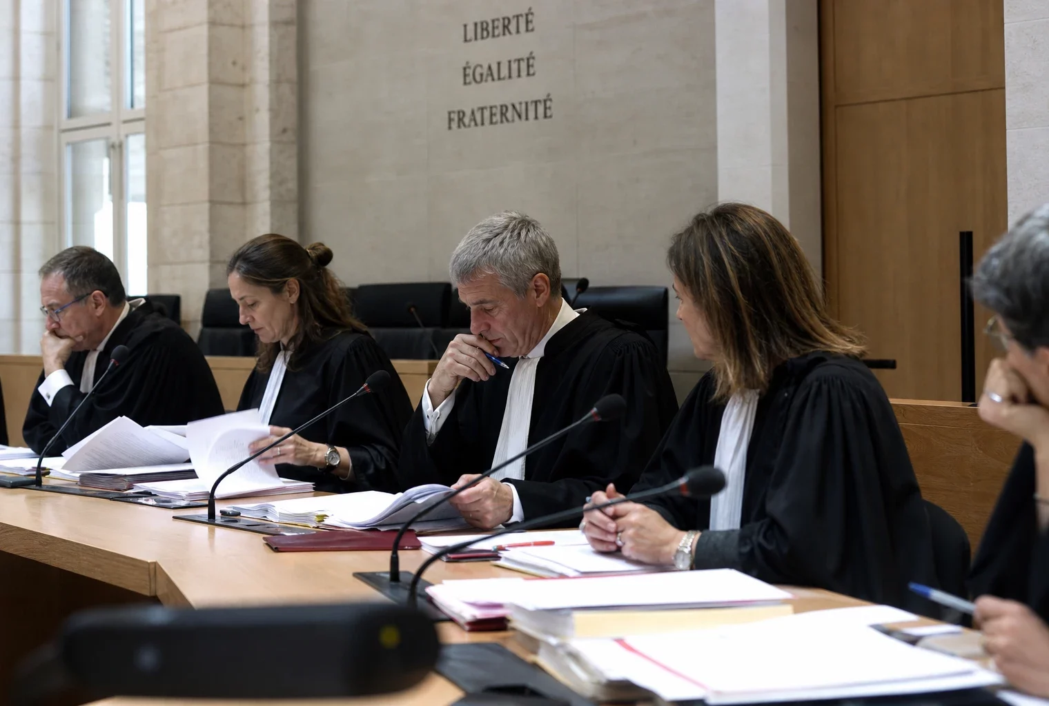 Dans un tribunal français, des magistrats examinent un dossier d’assises spéciale autour d’une table