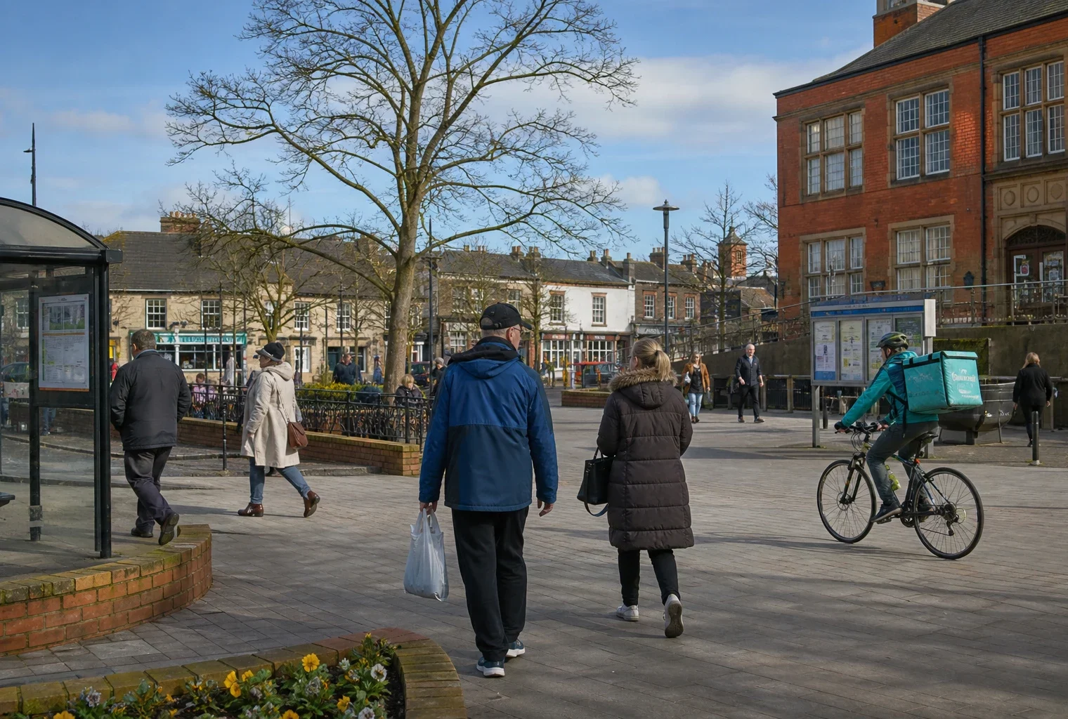 Place de ville moyenne anglaise avec habitants anonymes, mairie locale, arrêt de bus et logements en arrière-plan