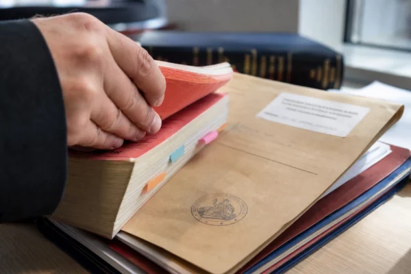 Gros plan d’un dossier judiciaire français avec code de procédure et tampon sur une table claire.