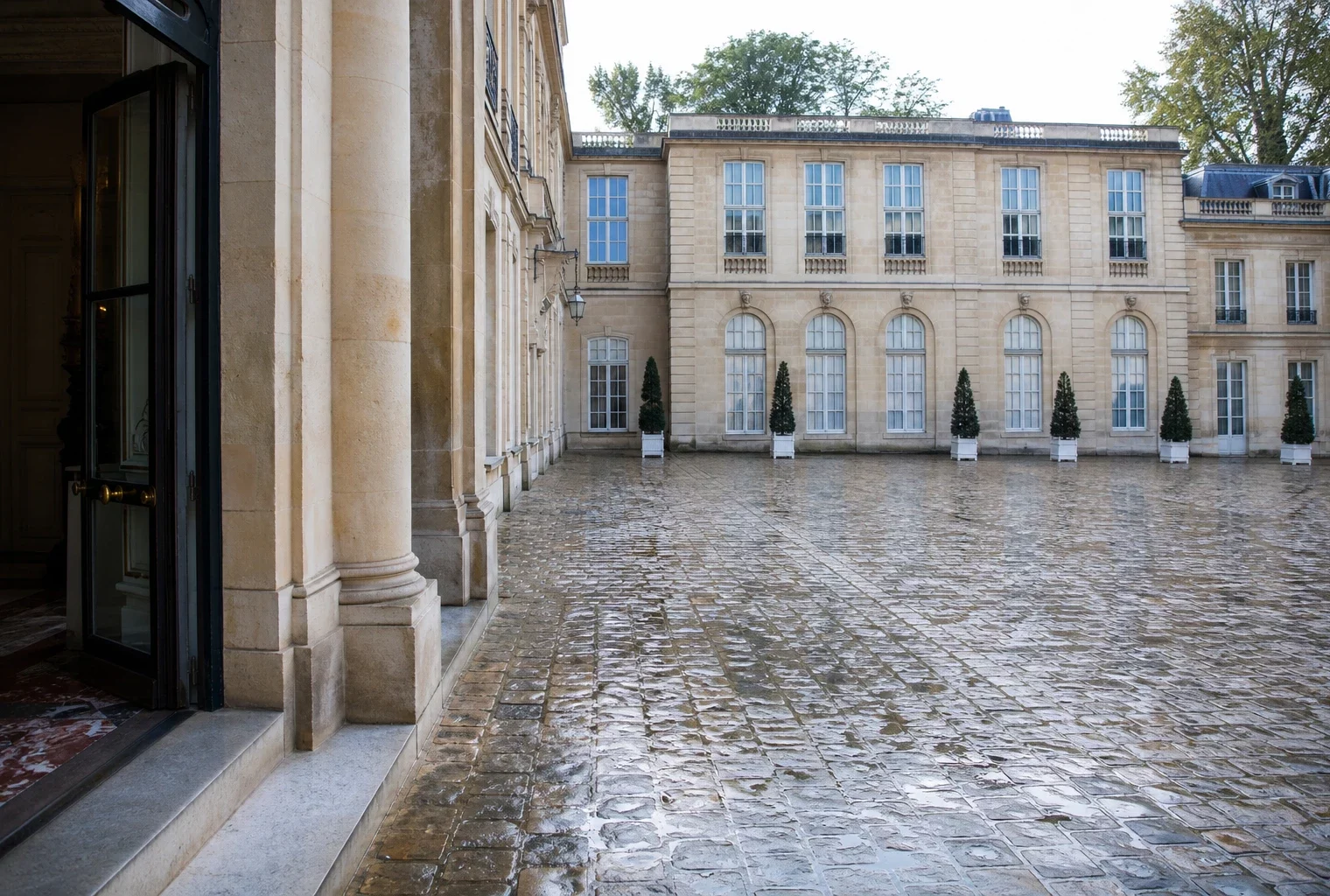 Cour d’une institution parisienne vue en oblique, sous une lumière claire, dans une ambiance politique sobre.