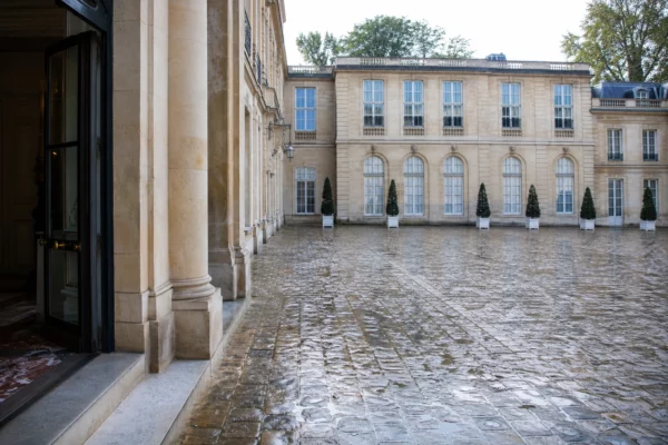 Cour d’une institution parisienne vue en oblique, sous une lumière claire, dans une ambiance politique sobre.