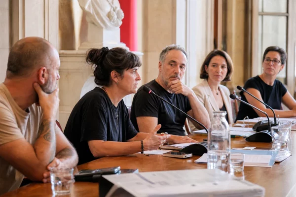 Réunion de presse municipale à Grenoble après l’arrêt d’un concert, avec plusieurs intervenants autour d’une table.