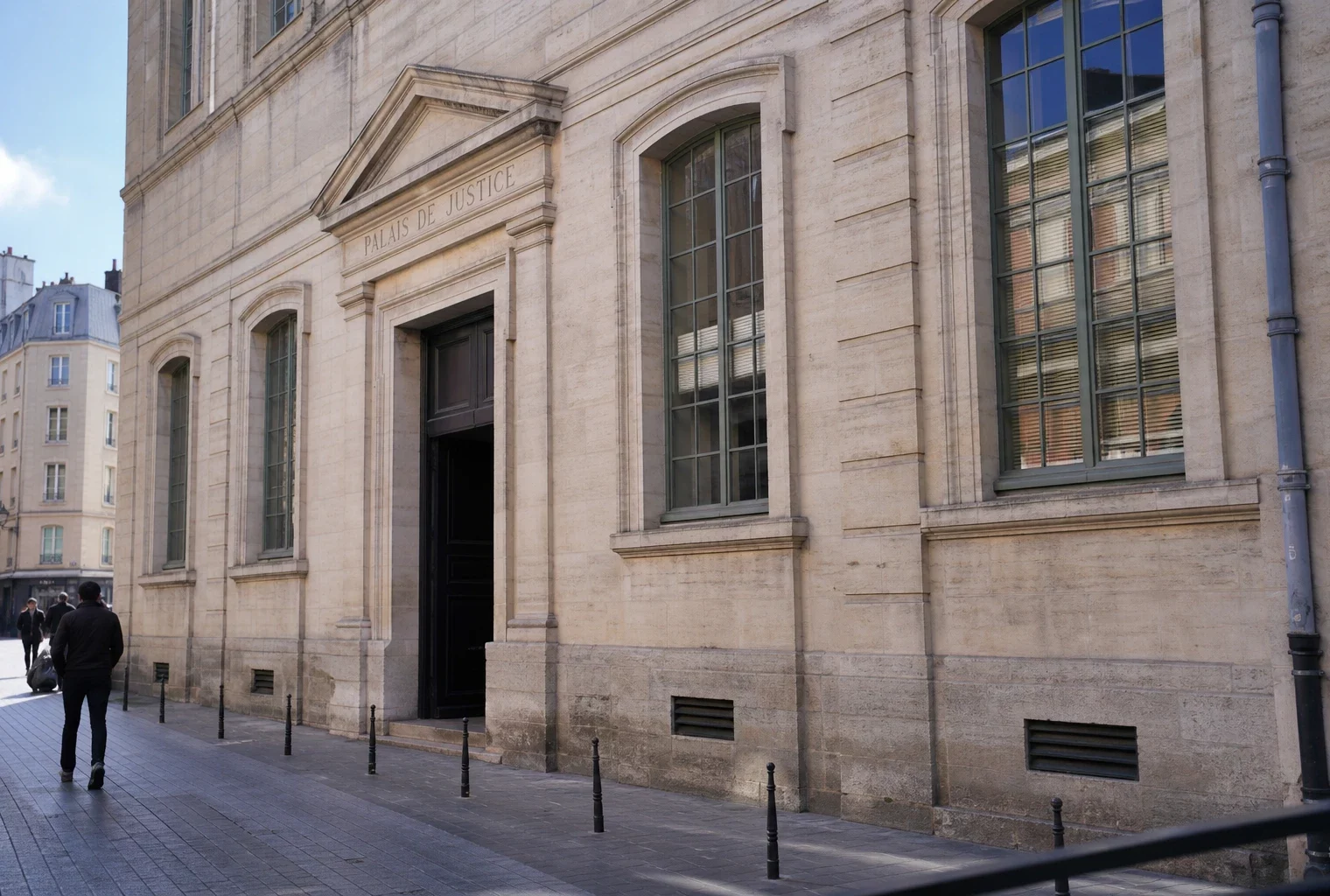 Façade d’un palais de justice français sous une lumière claire, pour illustrer un bras de fer juridique politique.