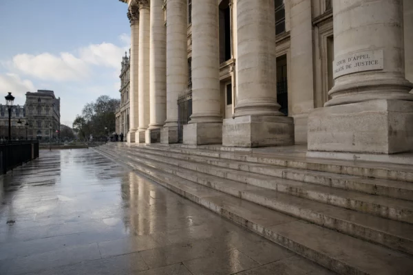 Façade du Palais de justice de Paris au matin, avec marches humides et ambiance institutionnelle calme