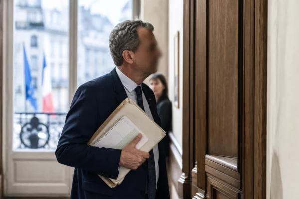 Élu local anonyme dans un couloir de mairie, dossier à la main, en lumière naturelle et ambiance de réunion politique.