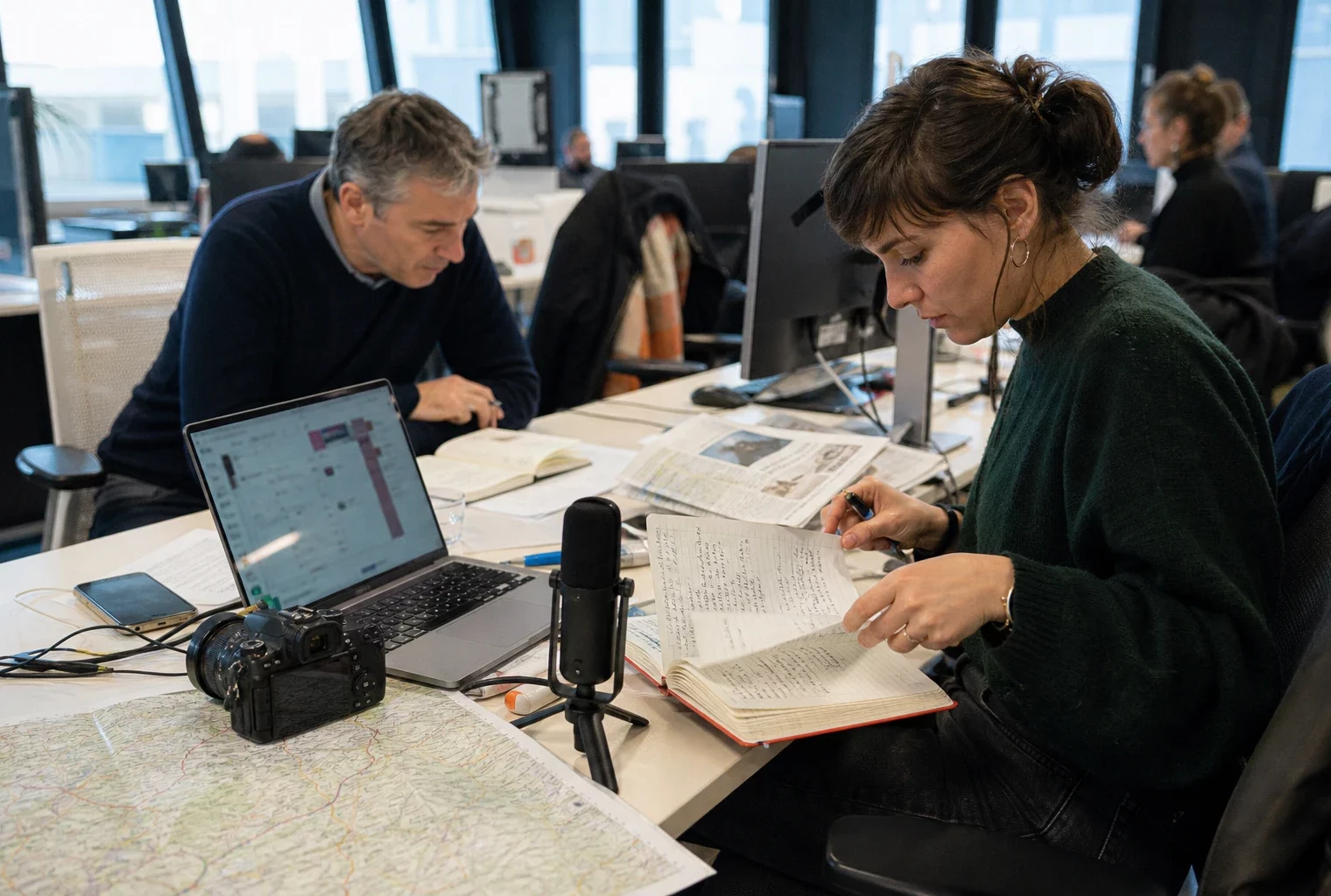 Journaliste en rédaction préparant un sujet sur la restauration des forêts après les incendies