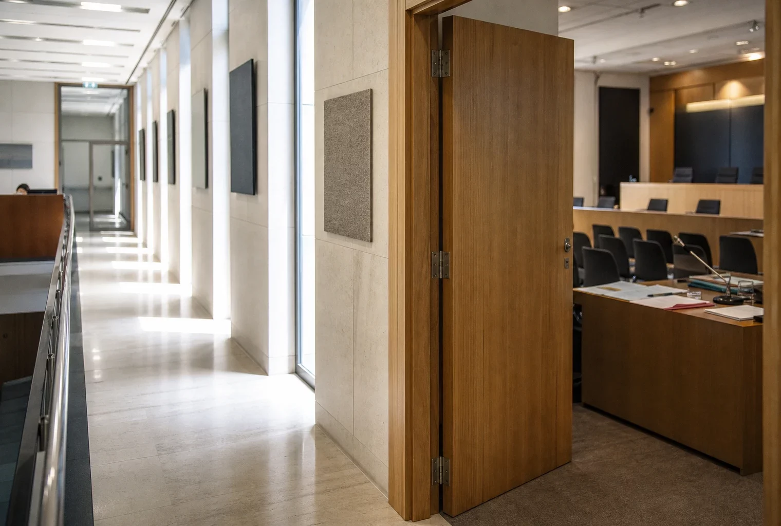 Couloir clair d’un régulateur français avec salle d’audition, lumière naturelle et ambiance institutionnelle sobre