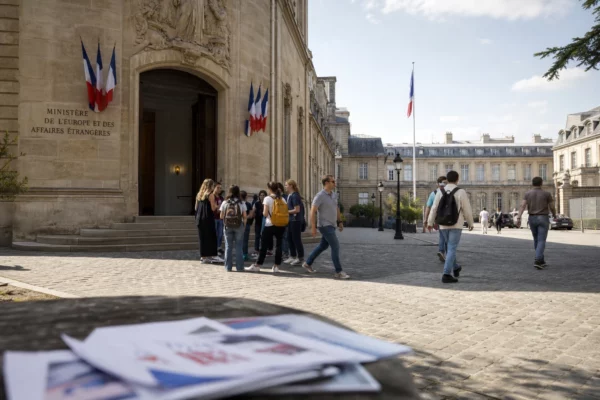 Des visiteurs traversent la cour du ministère français des Affaires étrangères à Paris, dans une scène de reportage claire et calme.