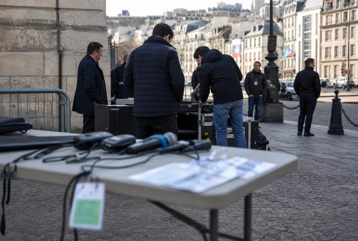 Scène documentaire calme près du Panthéon avec du matériel de cérémonie et des agents anonymes en plein jour.