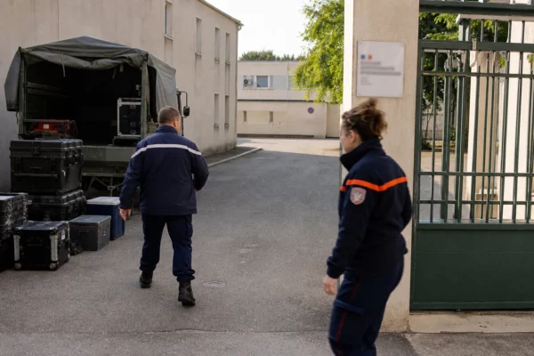 Reportage calme dans un site français de défense et de protection civile, avec matériel, camion utilitaire et silhouettes anonymes.