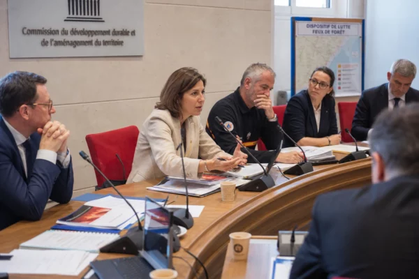 Réunion institutionnelle en France sur les retardants de feu, avec plusieurs experts autour d’une table et des dossiers ouverts.