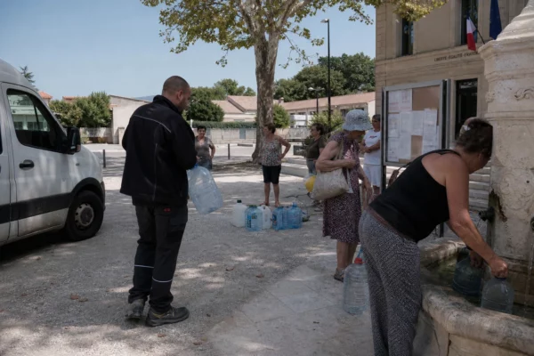 Des habitants attendent à un point d’eau municipal dans une commune française en pleine sécheresse estivale.