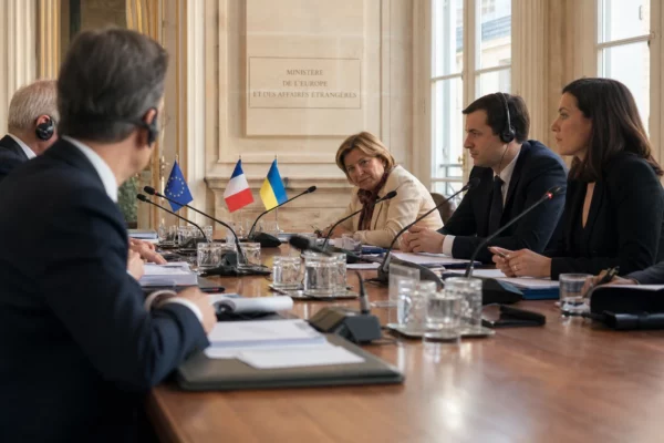 Table de négociation diplomatique en intérieur institutionnel français, avec dossiers, micros, écouteurs et silhouettes anonymes.