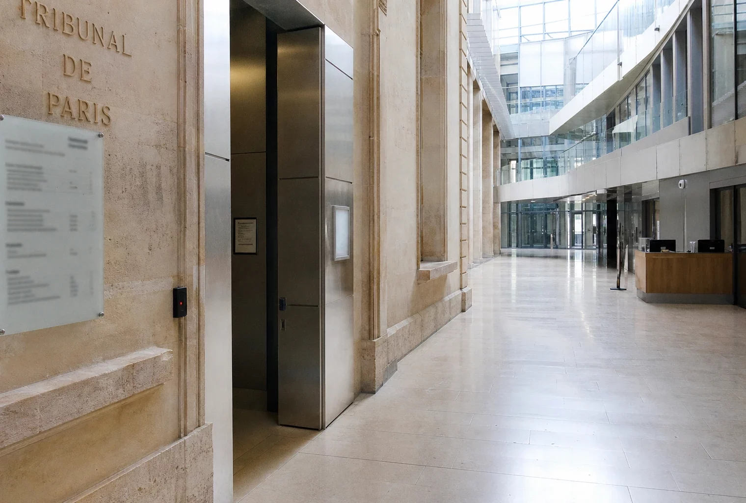 Intérieur vide du tribunal de Paris, architecture institutionnelle claire évoquant une enquête sur une cyberattaque.