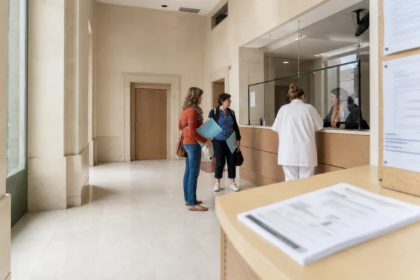 Hall clair d’une institution française avec une professionnelle accueillant une visiteuse pour l’accès à l’IVG