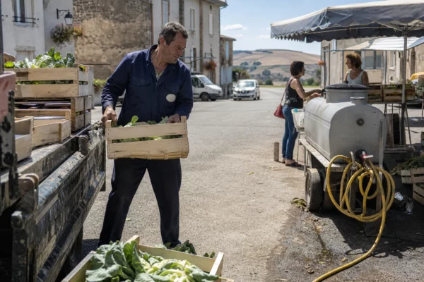 Agriculteur vendant ses légumes sur un marché communal, dans un contexte de sécheresse et d’aides agricoles incertaines