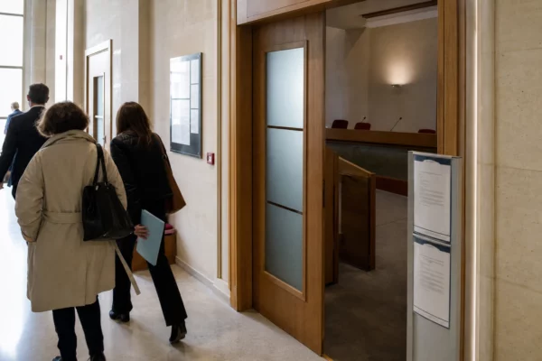 Hall lumineux d’une institution financière française, avec salle d’audition et dossiers liés au débat sur la dette publique