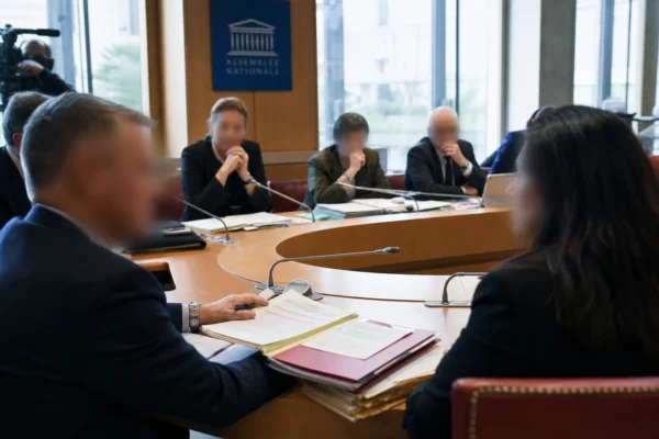 Réunion de commission parlementaire avec micros et dossiers, illustrant l’enquête sur l’altercation à Marseille