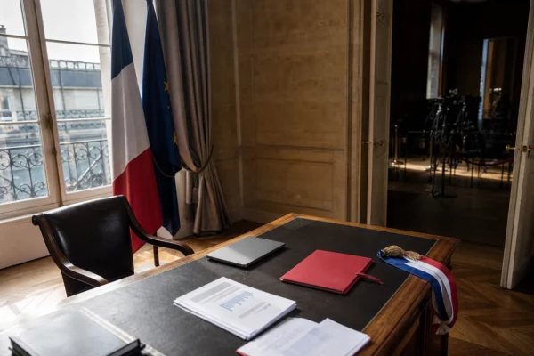 Bureau présidentiel français vide avec dossier rouge et chaise reculée, symbole d’une campagne politique sous tension