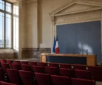 Salle de presse institutionnelle française vide avec pupitre, micros et lumière du matin, en ambiance sobre et claire.