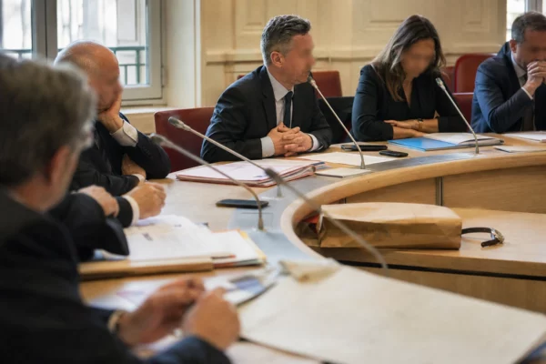 Réunion de commission parlementaire avec micros et dossiers autour d’une enquête sur un vol à Paris