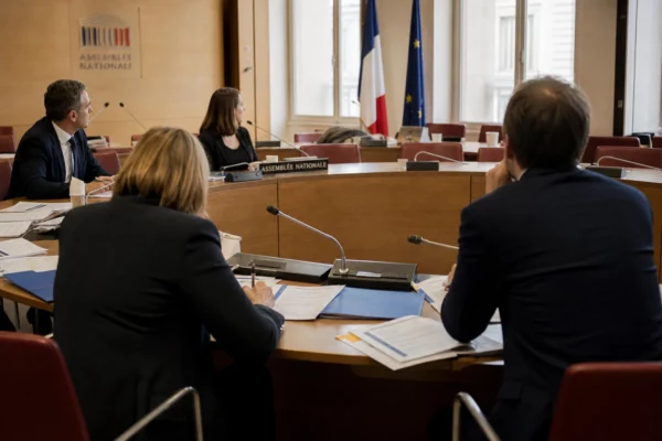 Réunion d’une commission parlementaire française sur les dépenses de communication de l’État, avec micros et dossiers