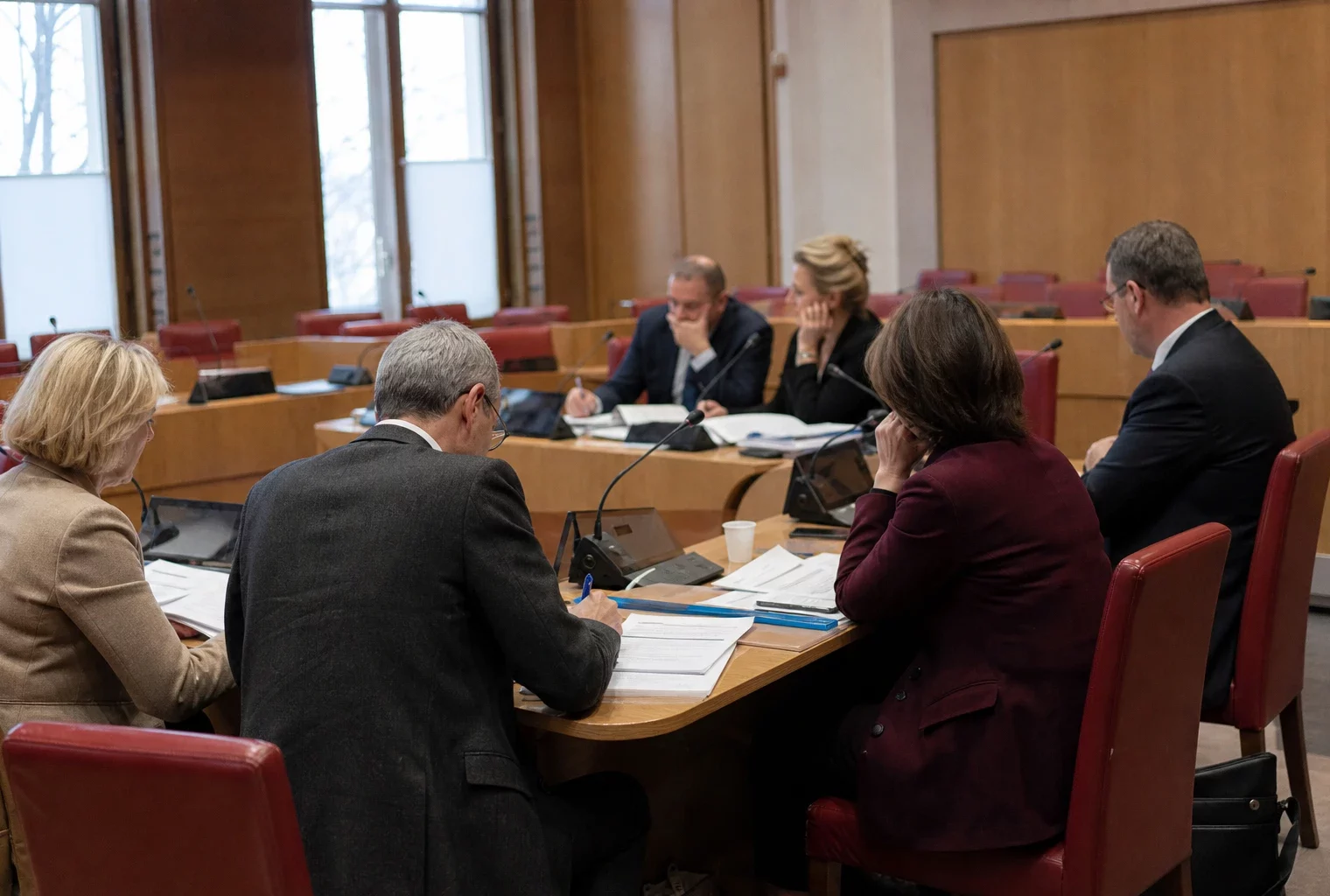 Réunion de commission parlementaire française avec élus anonymes, micros et dossiers autour d’une élection nationale