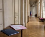 Couloir lumineux d’un bâtiment gouvernemental français avec dossier flou et ambiance institutionnelle calme.