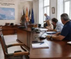 Salle municipale de Ceuta après une crise migratoire, avec chaise vide, micros et dossiers sur une table